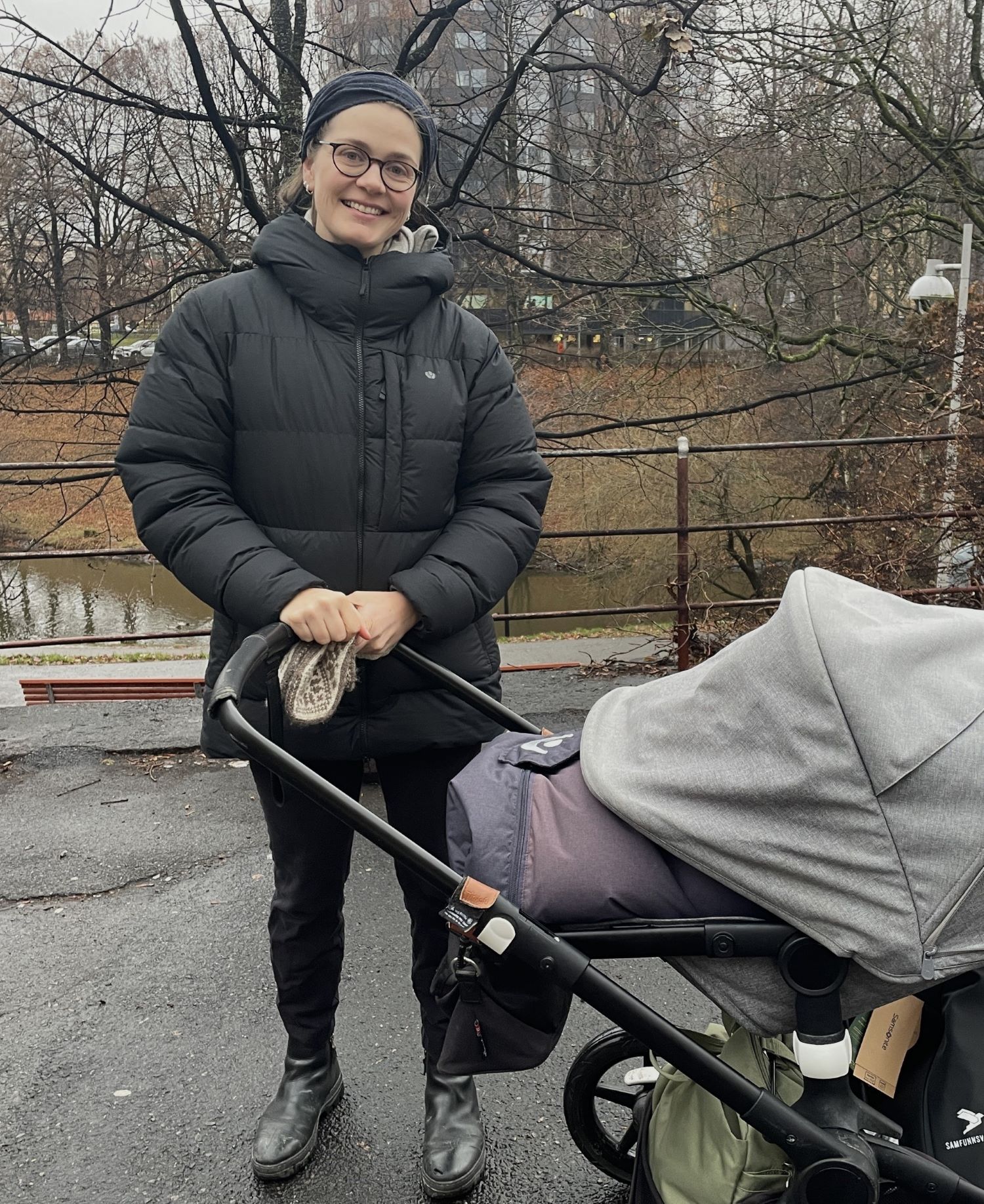 Ellen Arntzen står foran barnevognen og smiler.