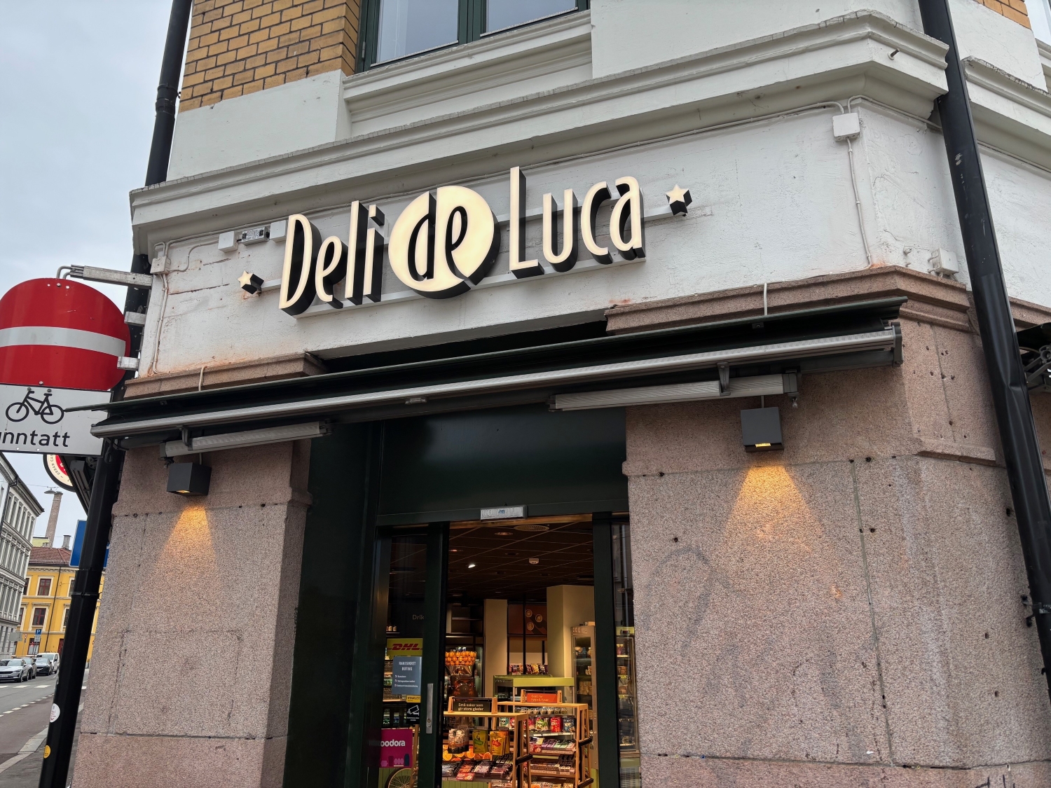 Murbygning på Grünerløkka med Deli de Luca-skilt over inngangdsøren