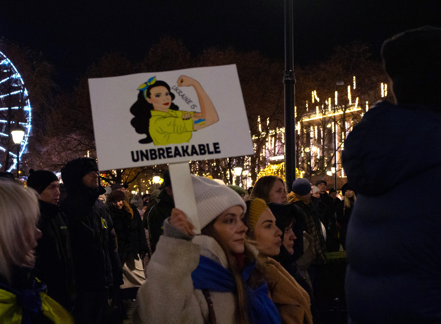 En jente holder opp en plakat hvor det står "Ukraine is unbreakable", under en demonstrasjon.