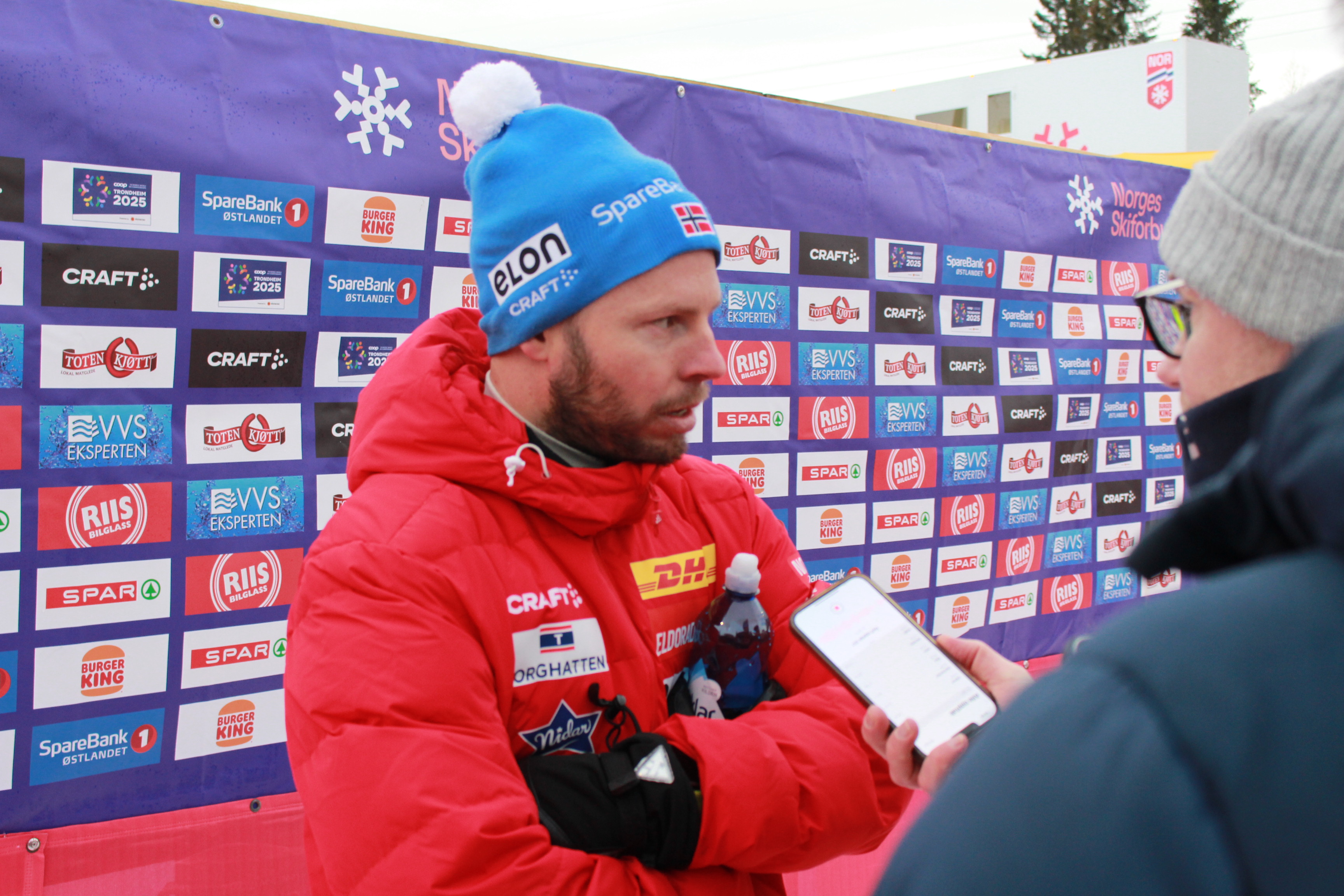 Eirik Myhr Nossum blir intervjuet foran en pressevegg.