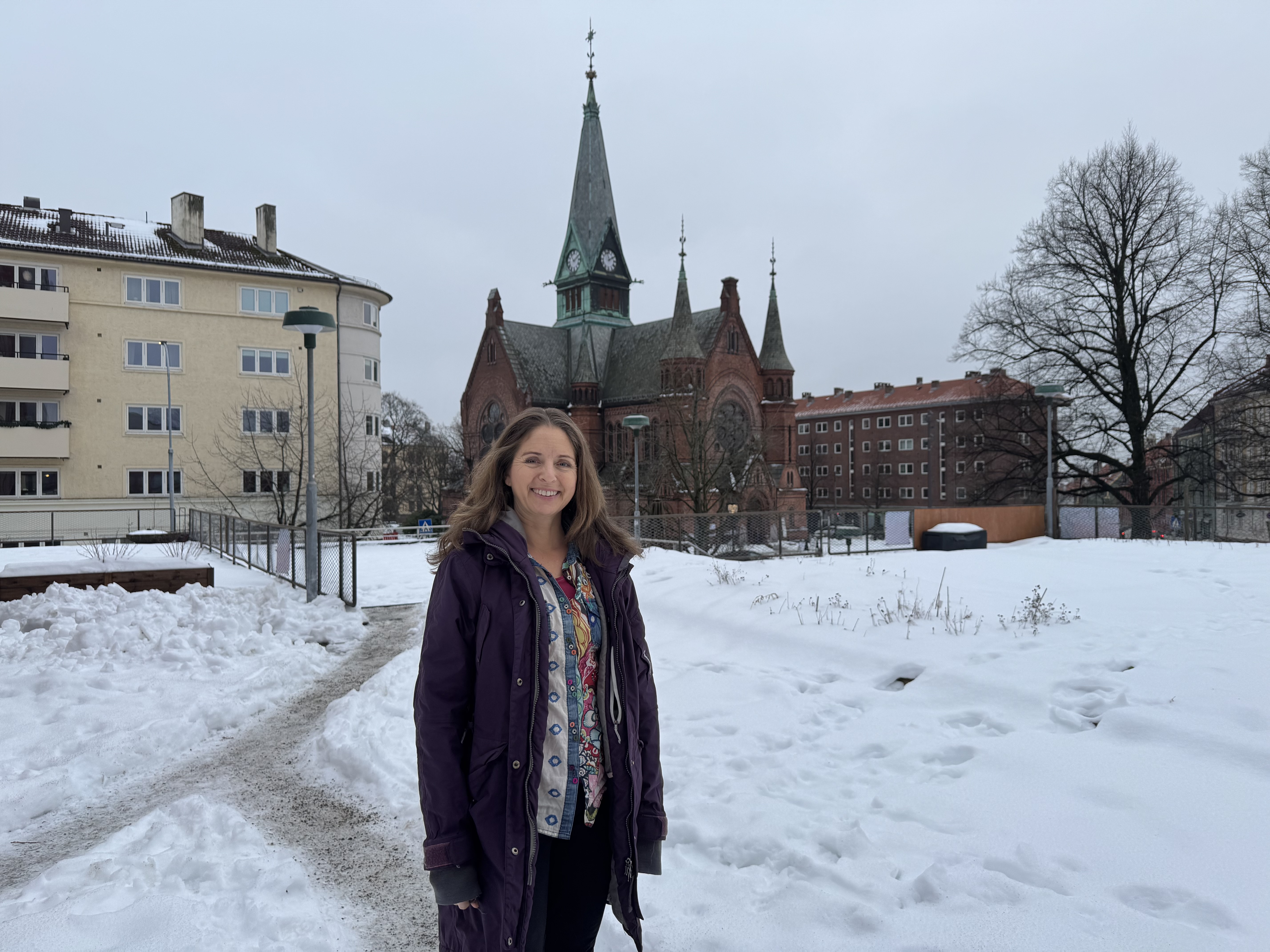 Jannicke Wiel står utenfor Sagene kirke og smiler