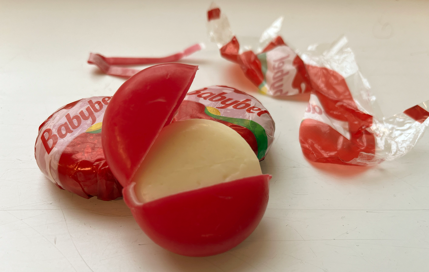 Tre babybel hvor den ene er åpnet 