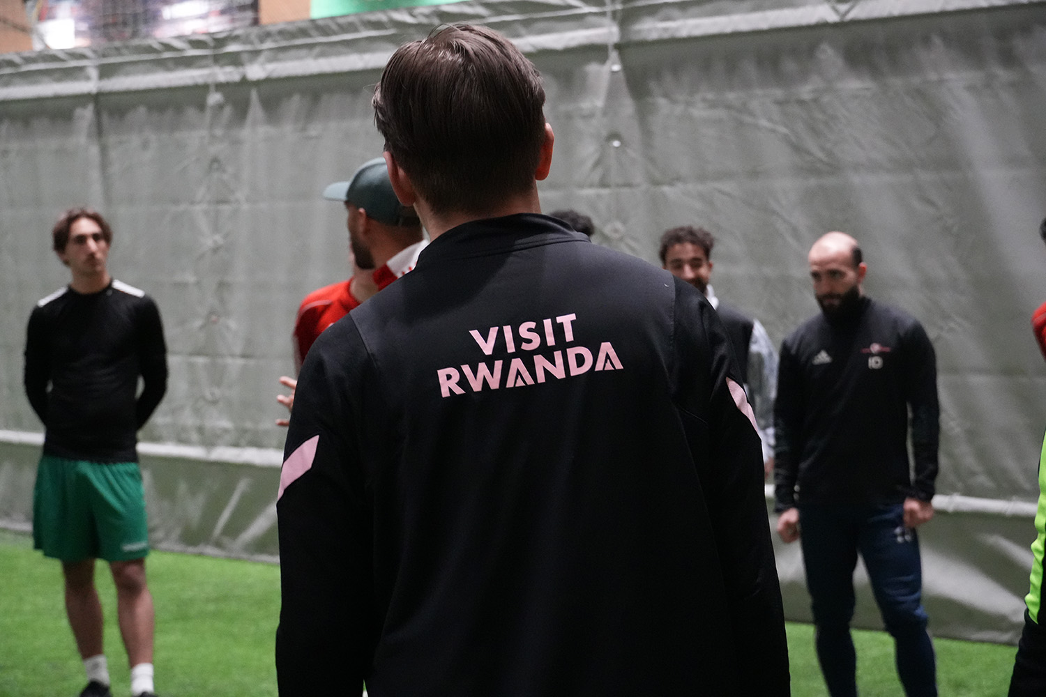 Viser ryggen til en av spillerne. På drakten står det "Visit Rwanda"