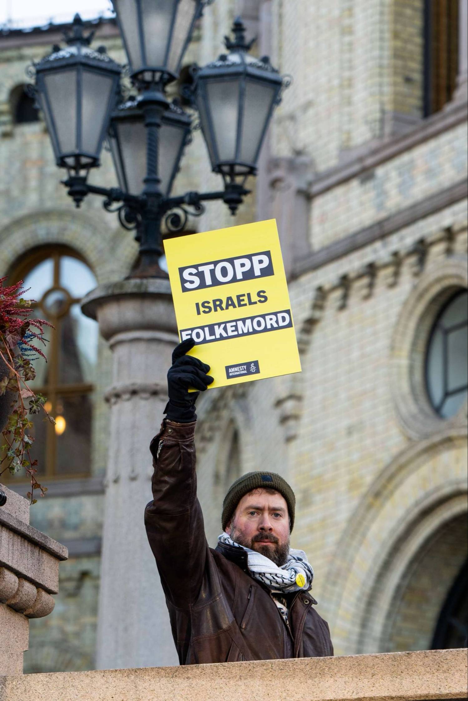 man som holder plakat i protest mot israel
