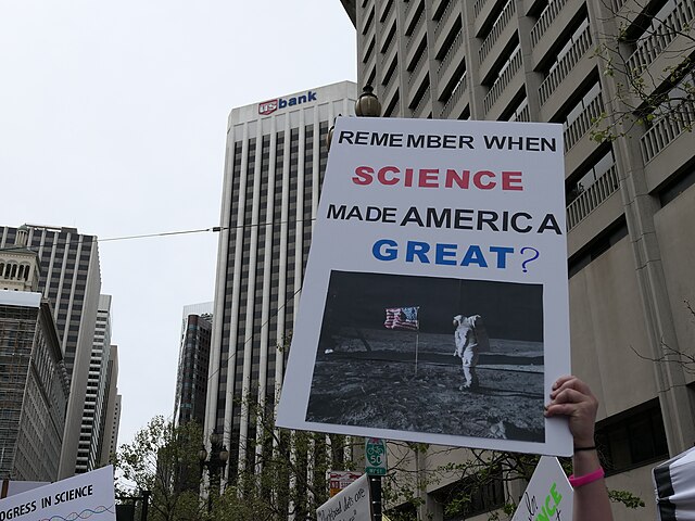 Demonstrant holder opp en plakat der det står "remember when science made america great?"
