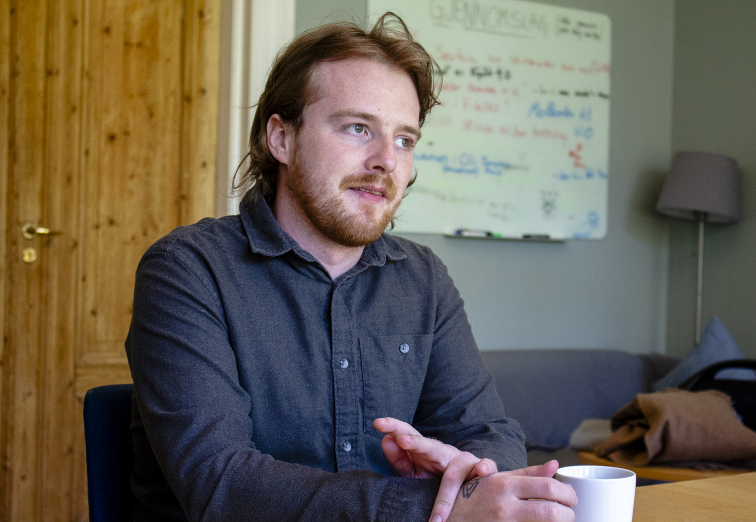 Sondre Klungland sitter med en kaffekopp inne på et kontor