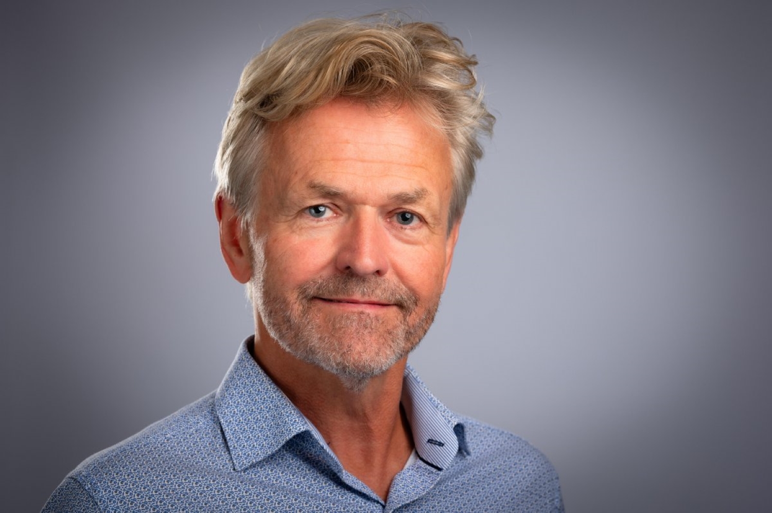 Mann med blå skjorte og blondt hår