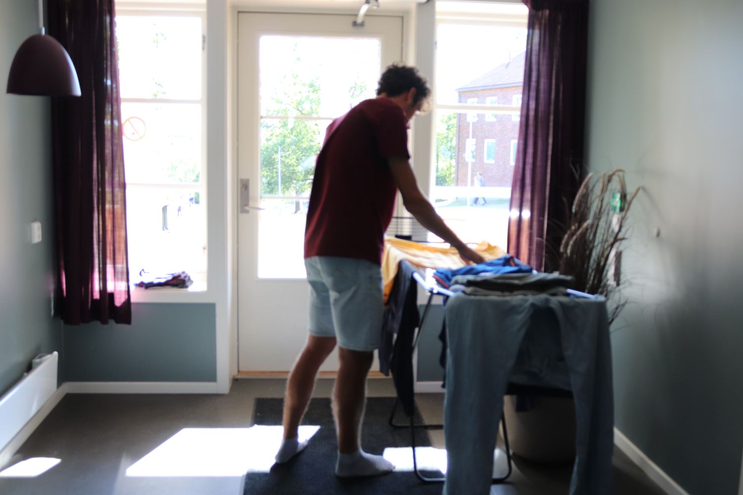 En ung mann som henger opp klær på et klesstativ