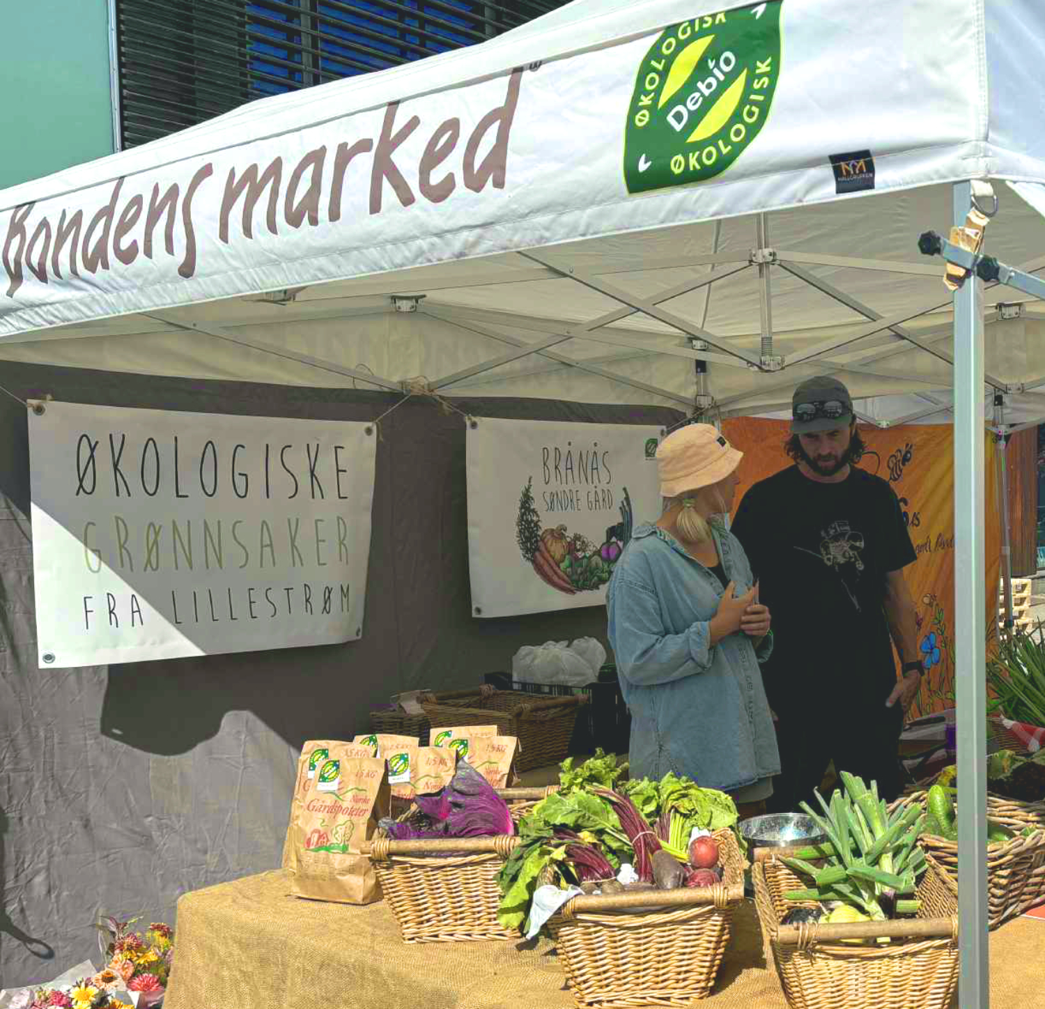Et par, som også er bønder, står og snakker sammen mens de selger grønnsaker på Bondens marked i Lillestrøm.