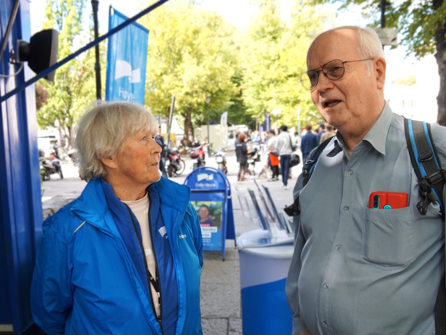 Eldre mann og kvinne foran Høyres valgbod