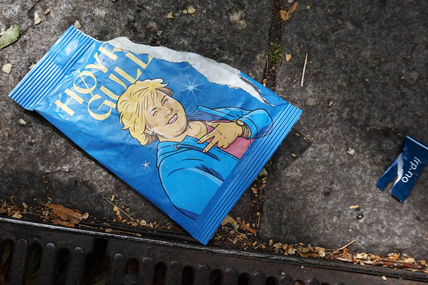 Tom potetgullpose på bakken med bilde av Erna Solberg