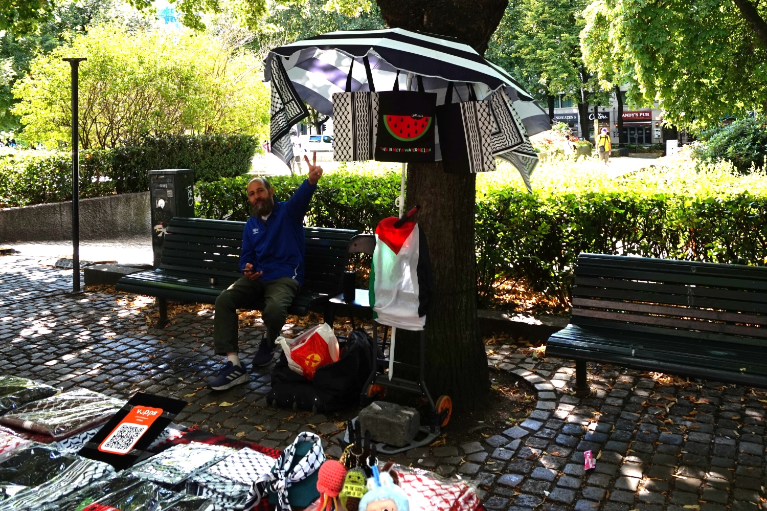 Mann viser "Peace"-tegn foran bod med palestinaskjerf