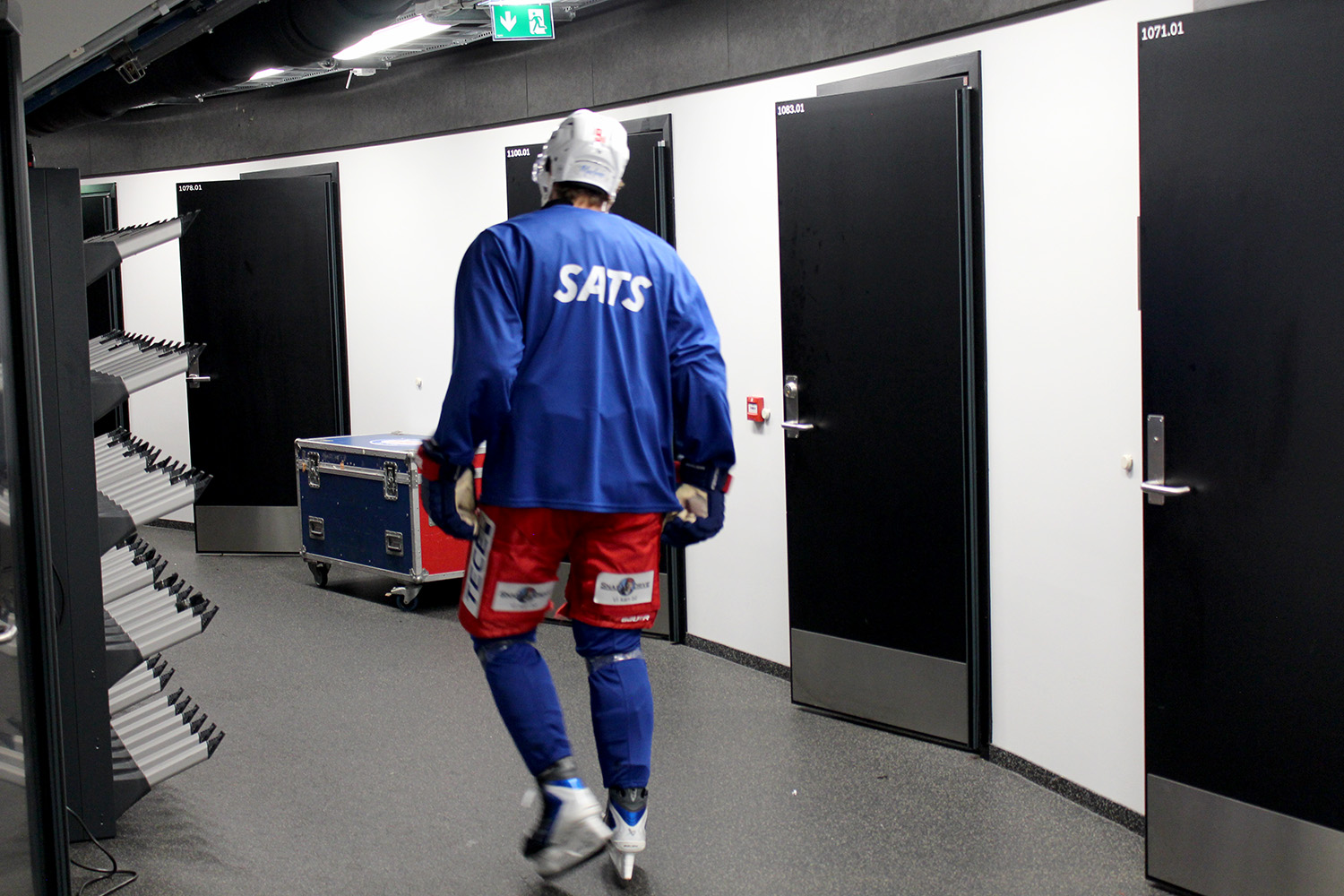 Spiller går med ryggen til i gangen