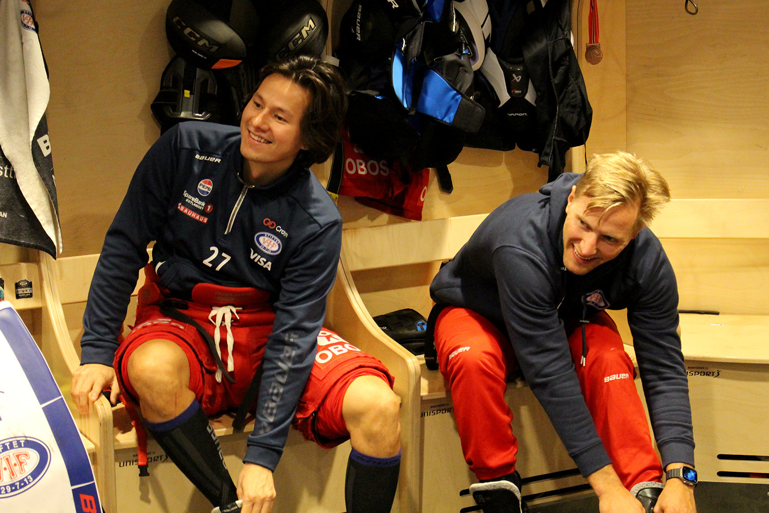 Spillere sitter ved siden av hverandre i garderoben.