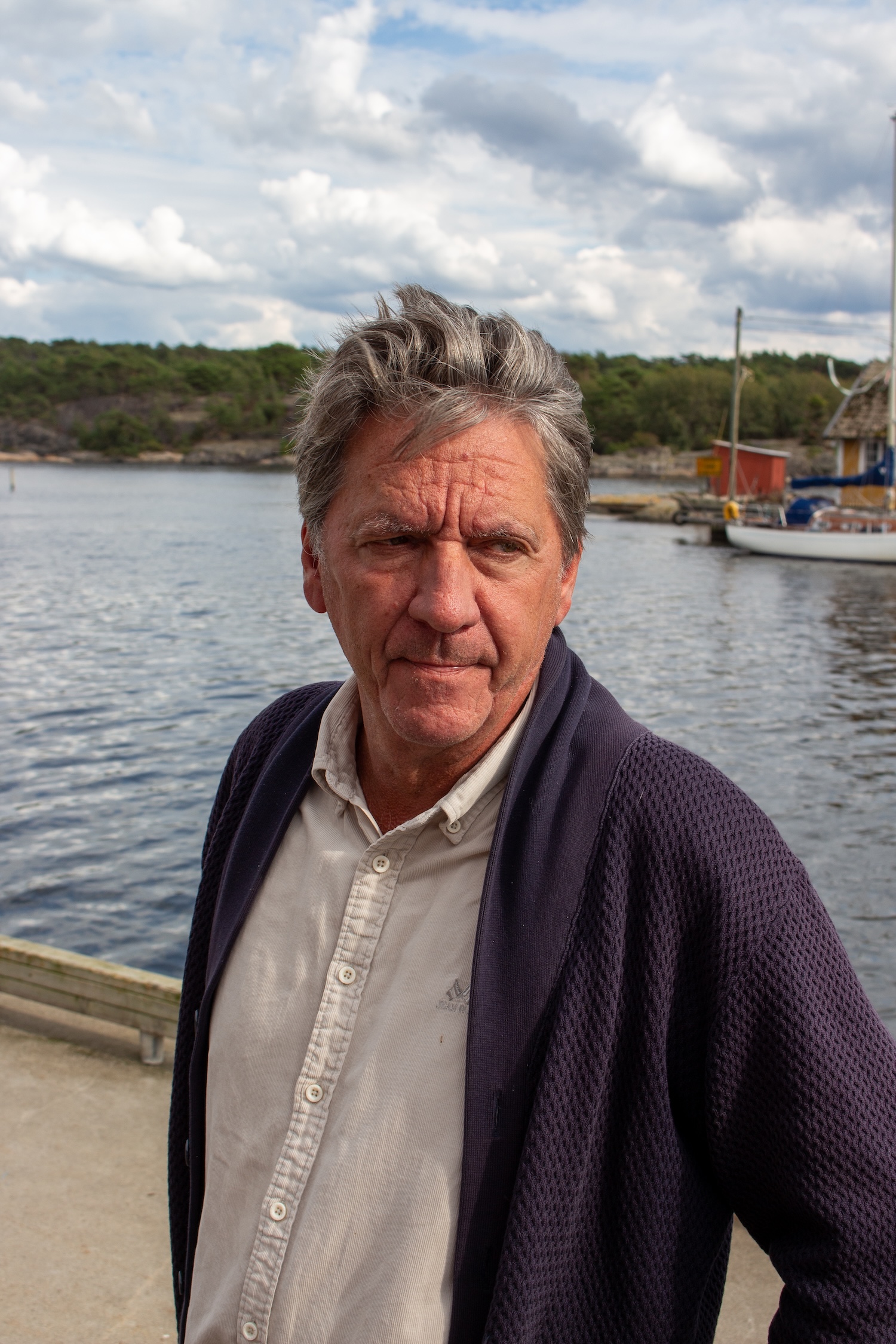 Mann som står på brygga foran havet