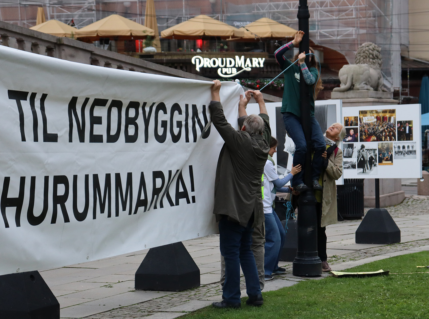 personer henger opp et banner. der står det nei til nedbygging av hurummarka