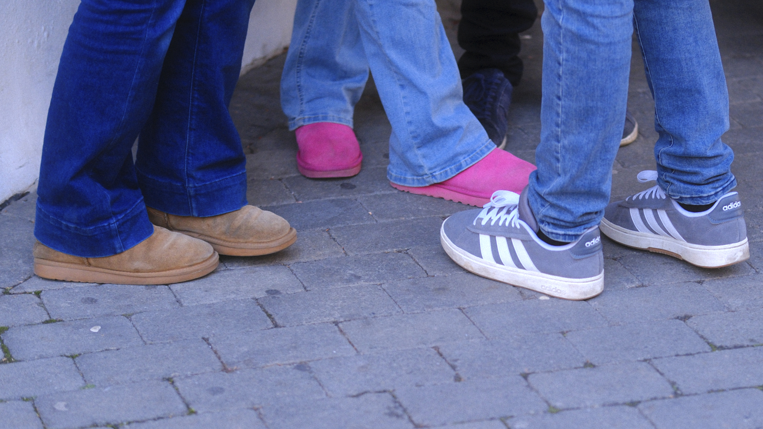 Bilde av tre bein med jeans og sko 