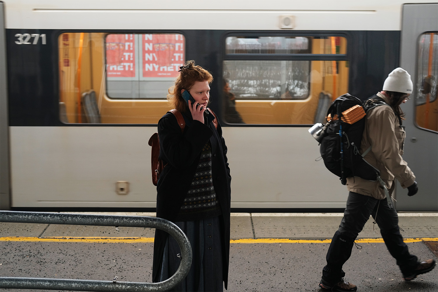 Jente utenfor t-bane som snakker i telefon