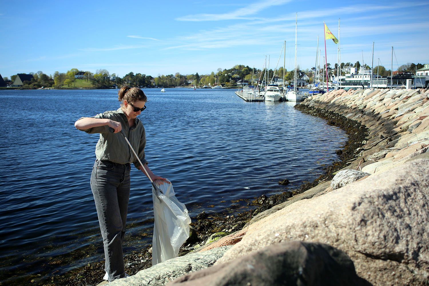 Iselin plukker s&oslash;ppel langs vannkanten ved Kongen Marina. 