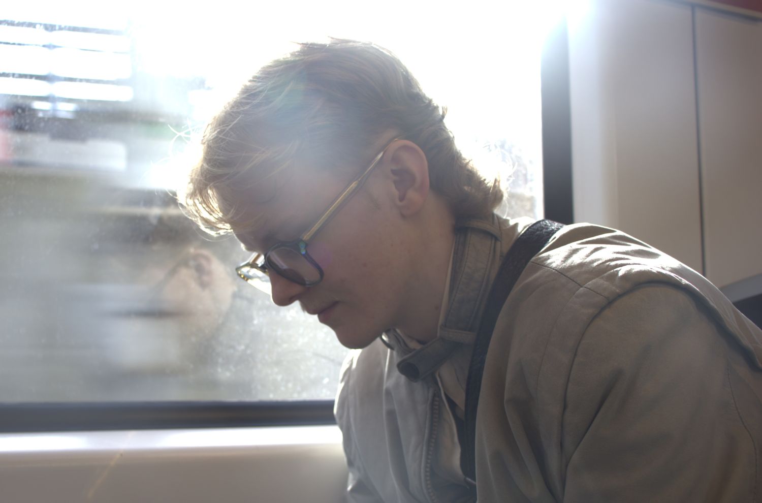 Mann sitter ved t-banevindu