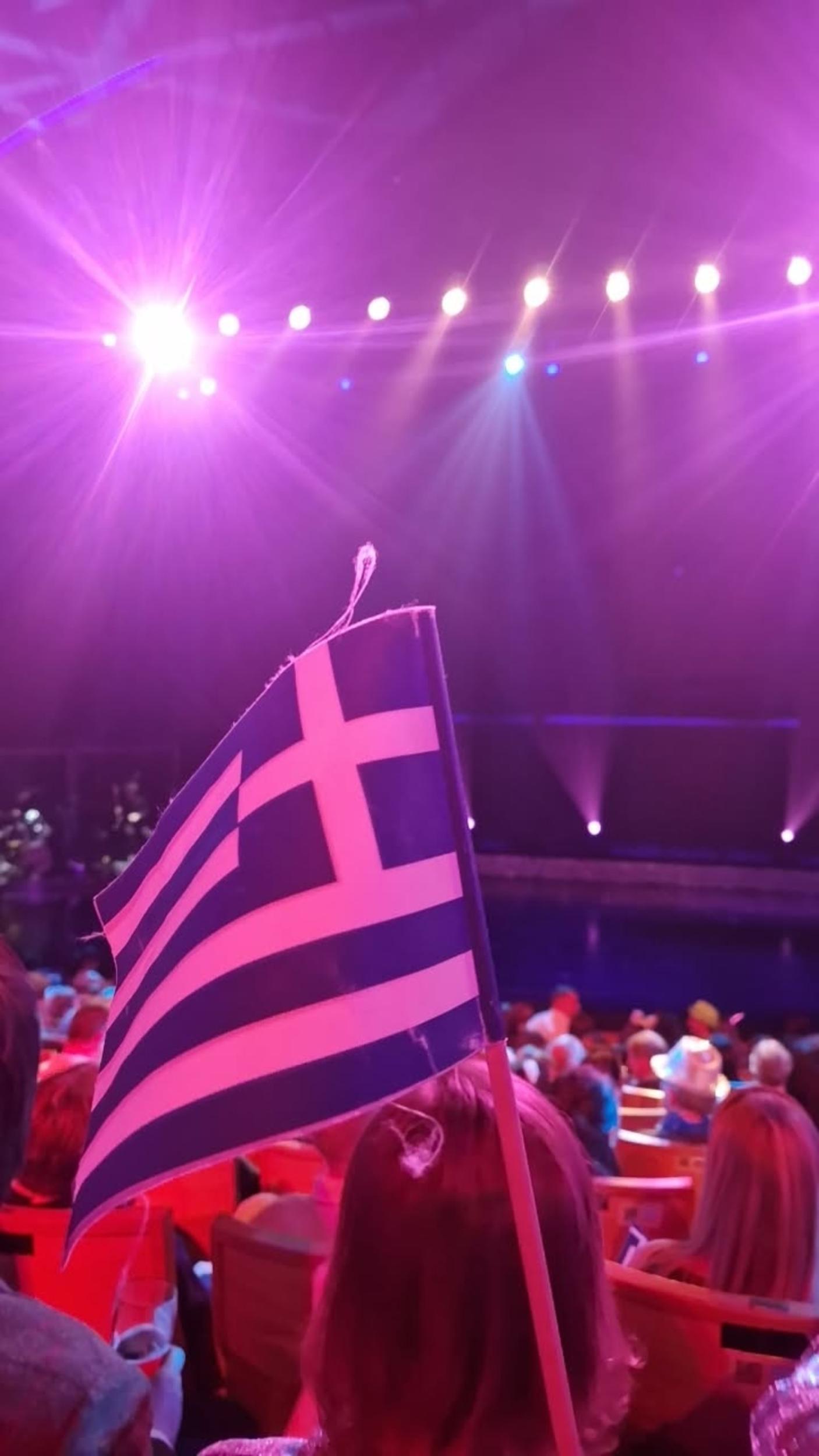 Hellas-flagg veives foran en scene