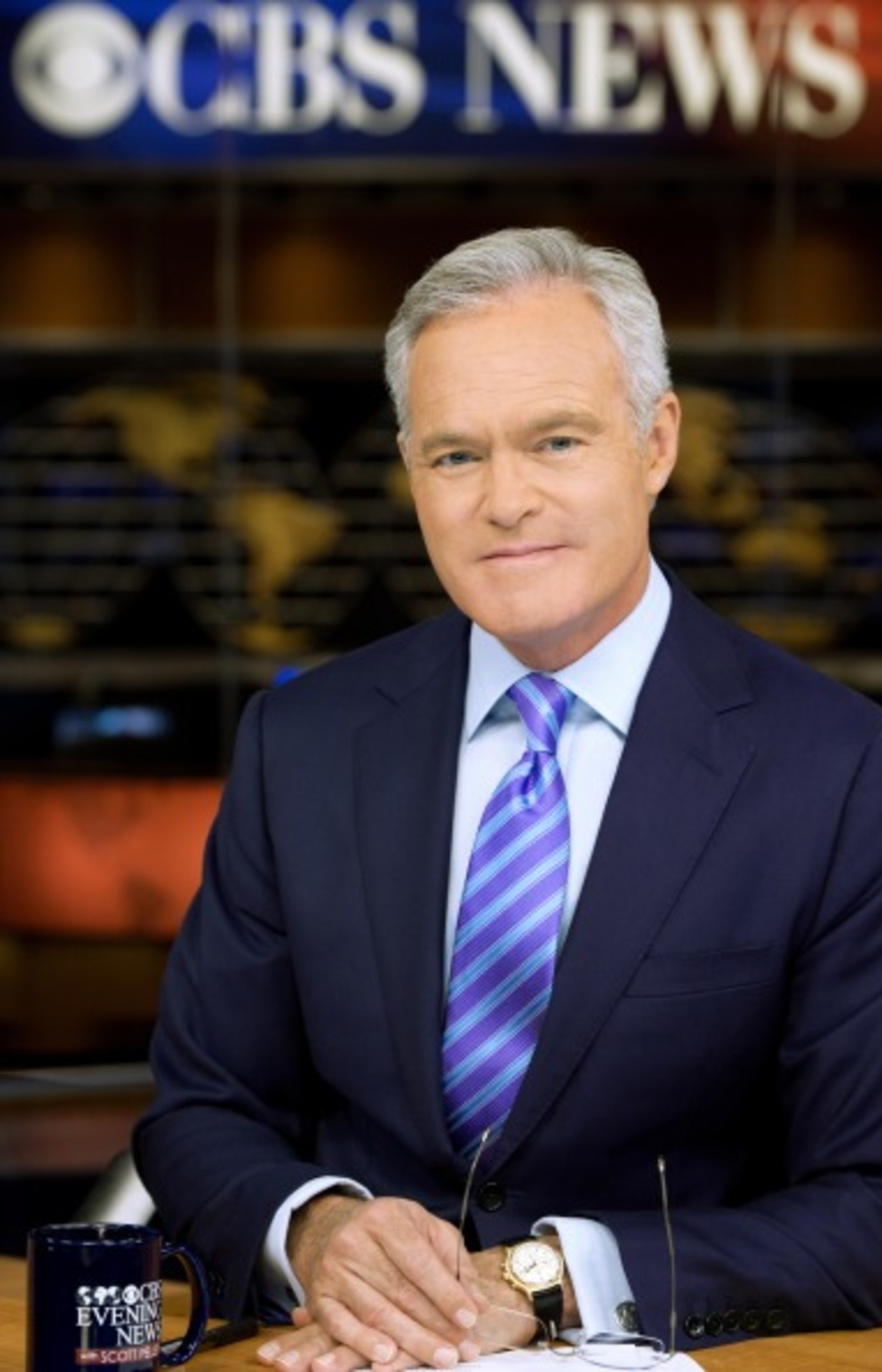 Journalist Scott Pelley ser mot kameraet. Bak ham st&aring;r det CBS News. Portrett