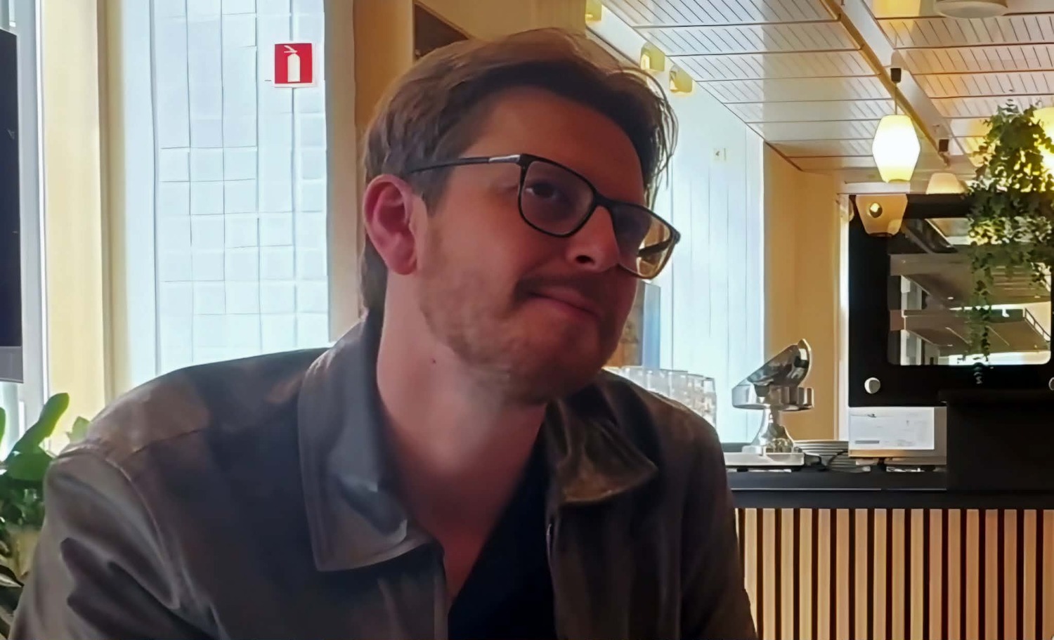 Mann ser mot intervjuer til h&oslash;yre for kameraet