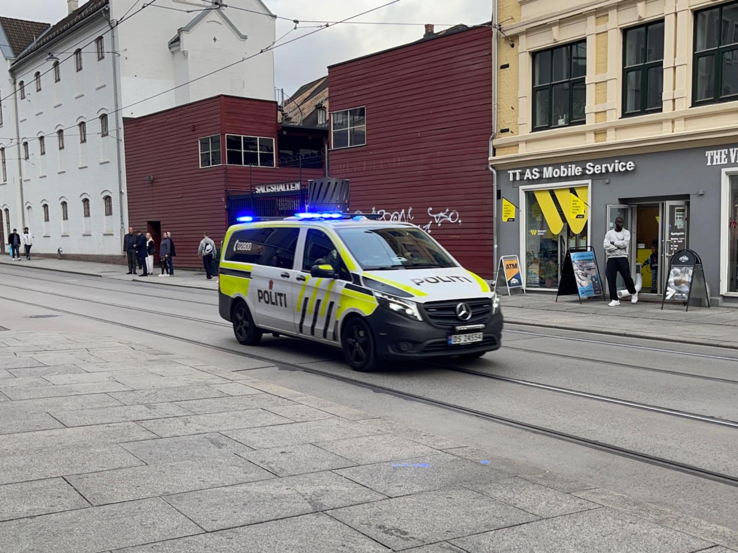 En politibil med blålys kjører gjennom Storgata i Oslo.