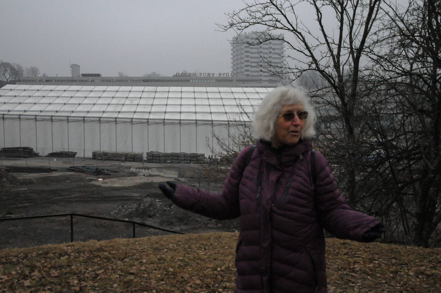 Kvinne med lilla boblejakke forteller. 