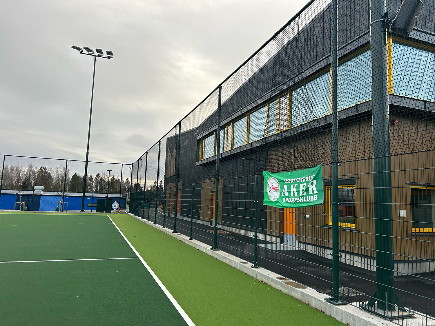 Utendørs fotballbane med Mortensrud Aker Sportsklubb flagg