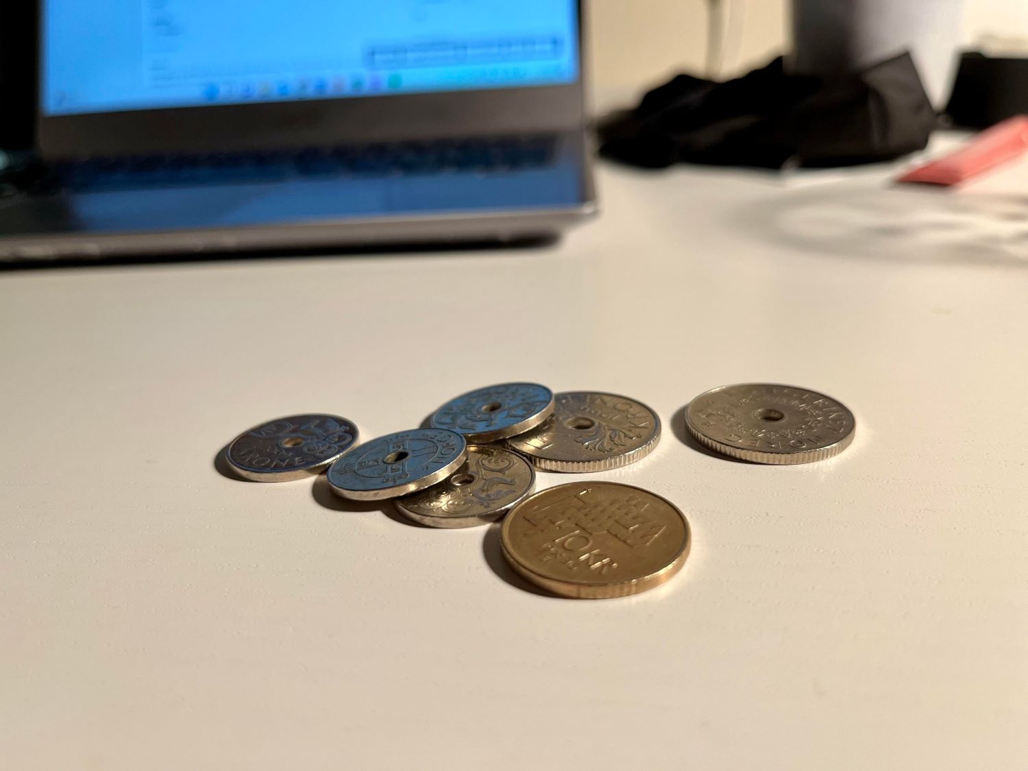 Norske mynter ligger på et skrivebord