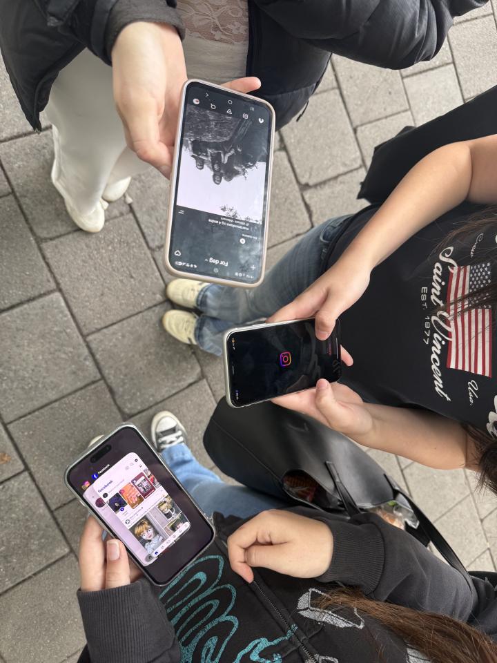 Tre venninner som har Instagram og Facebook på telefonskjermene