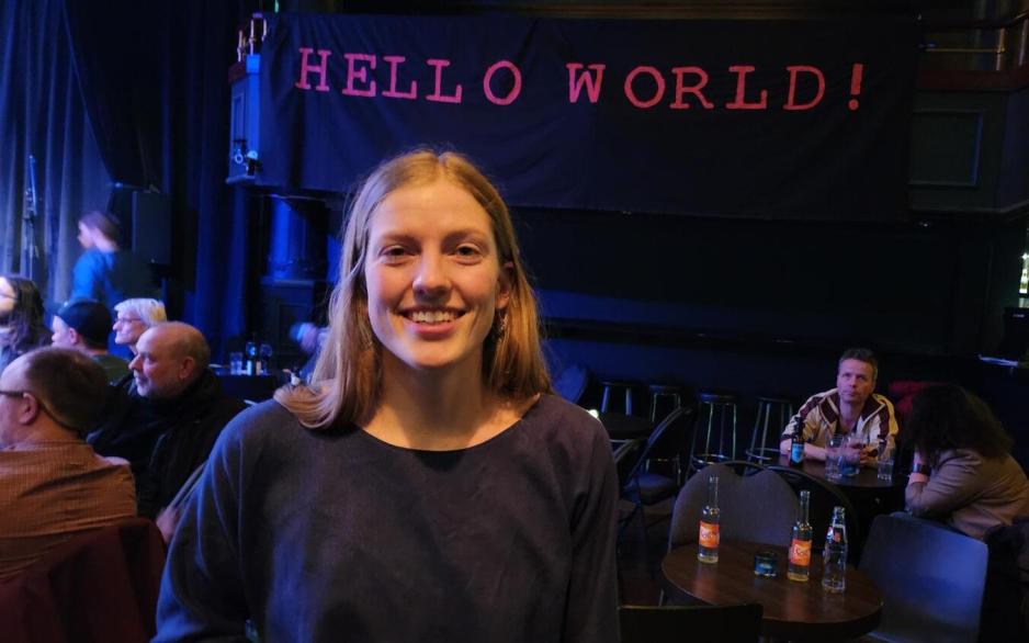 Bilde av Anna Ueland forran banneret deres "HELLO WORLD"