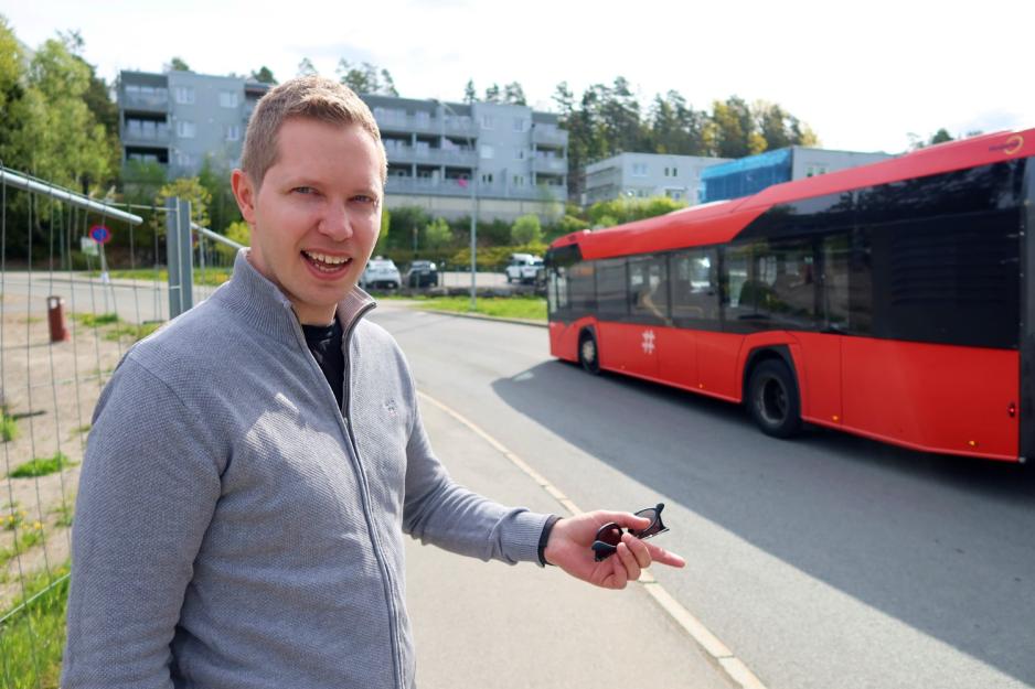 Morten Punnerud og en buss Morten Punnerud står ved veien og en buss kjører forbi.