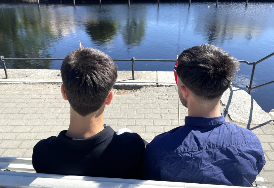 brødre sitter tett på benk