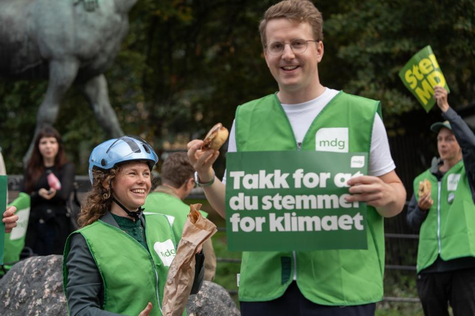 Ingrid Liland deler ut boller til frivillige på valgdagen En mann og en dame, mannen holder en bolle i hånda