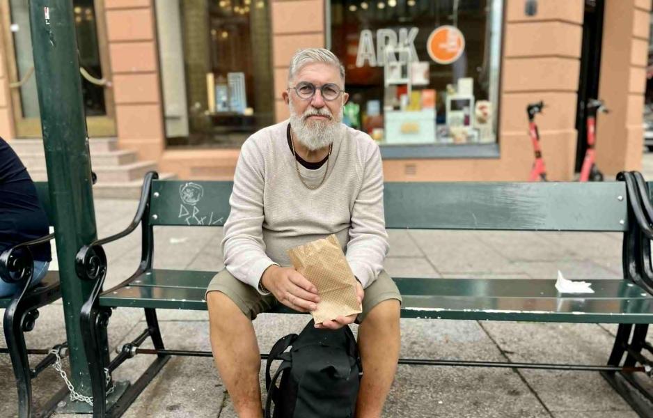 En man sitter på en benk på Karl Johan