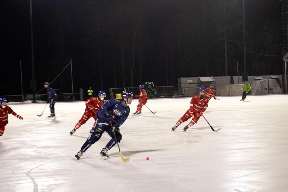 En bandyspiller som er duell med to andre spillere