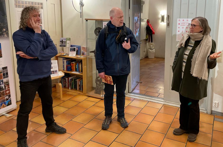 Ellen Martha Blaasvær forteller en entusiastisk Reiner Schaufler ny informasjon om en steintavle han ikke visste fra før av. 