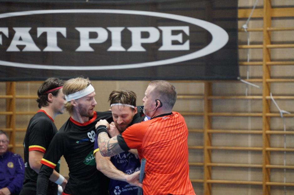 Dommeren må bryte inn mellom to spillere som krangler 