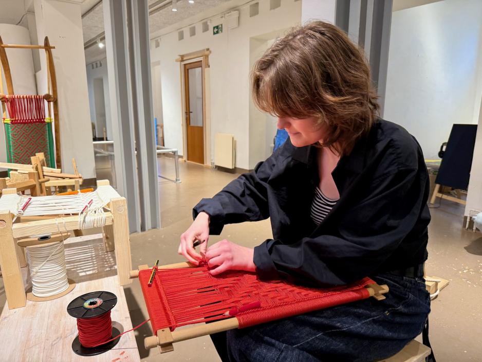 Ella Rørmark sitter og vever