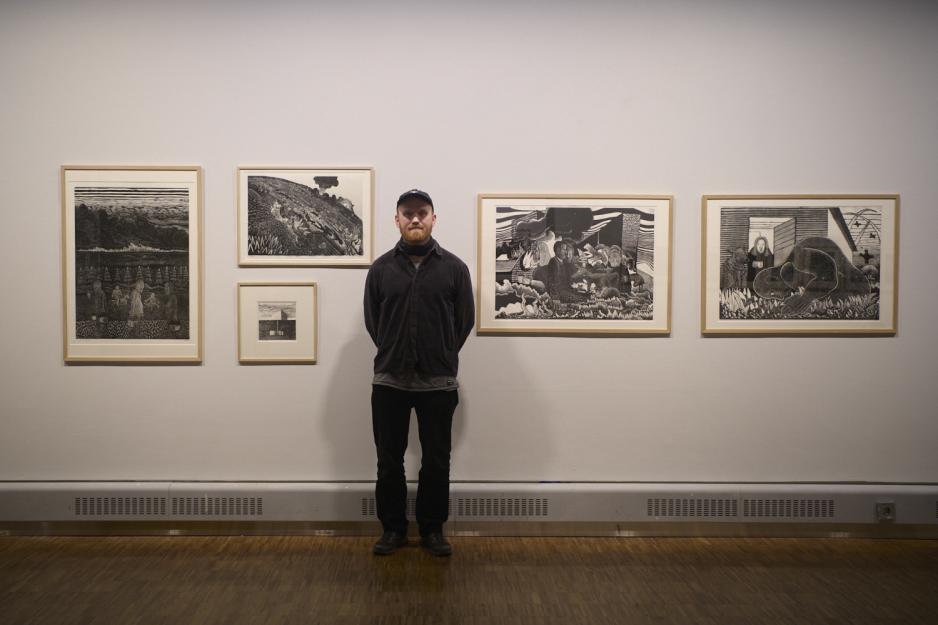 Kunstner Eirik Lillebror Mikkelborg ved verkene hans.