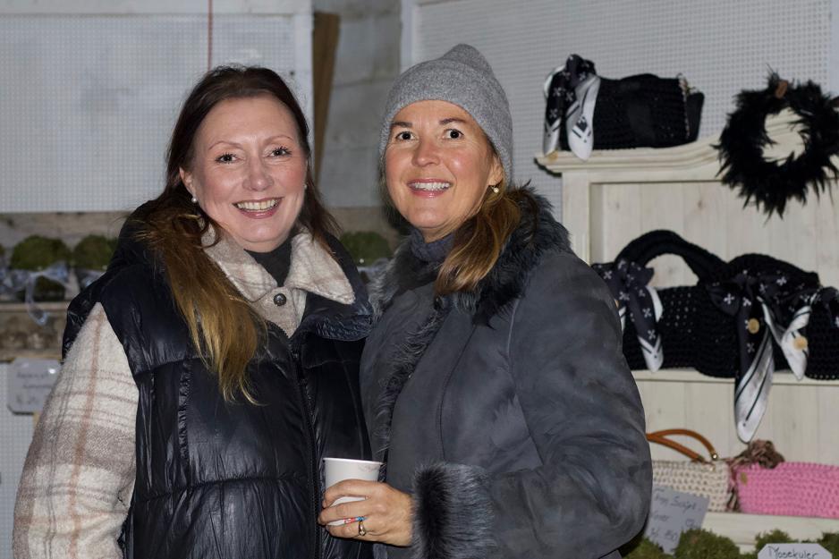 Therese Lunde og Irene Borge-Hansen står foran julemarkedet.