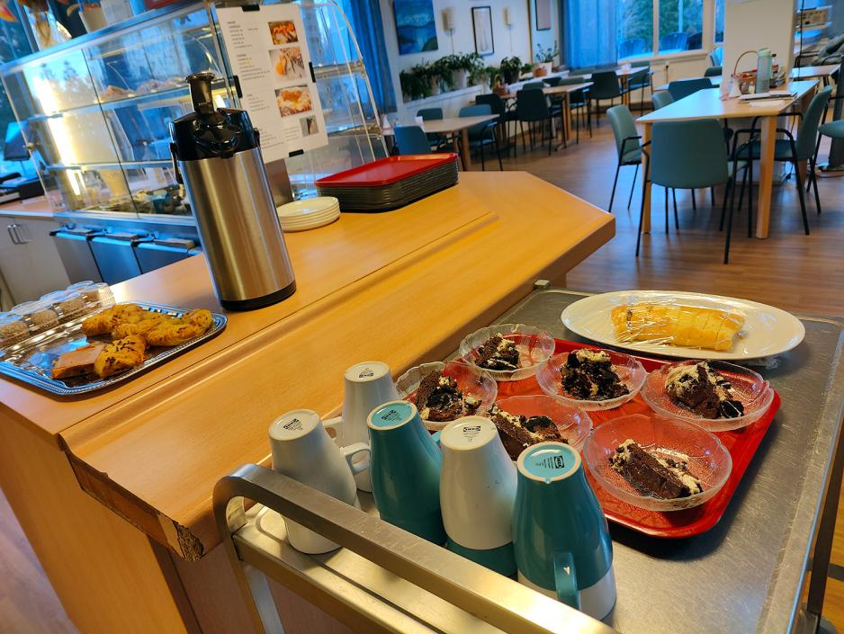 Bord med rullekake, kaffekopper i kafélokale