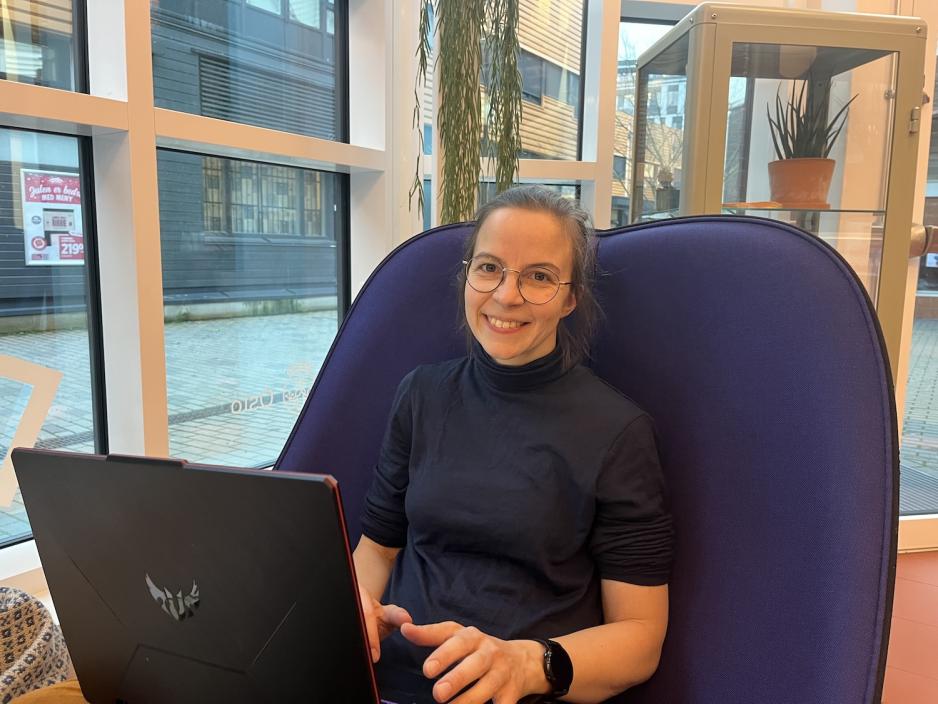 Karine sitter i en stol på Deichman Holmlia