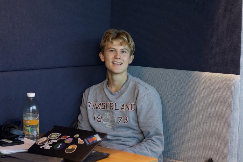 Et bilde av en gutt med navn Konrad Skarheim, han sitter på biblioteket. 