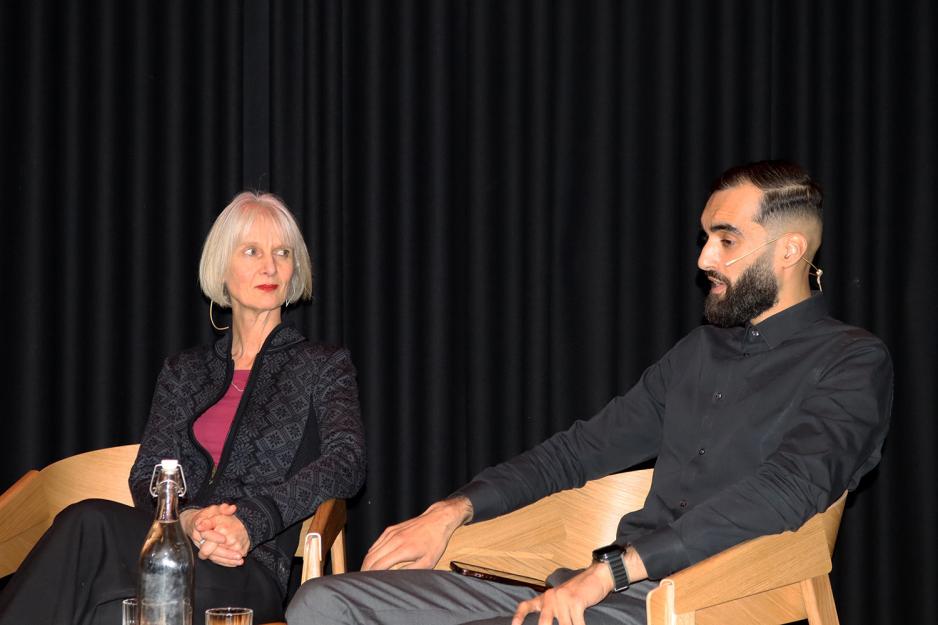 dame og mann sitter å snakker alvorlig på en scene