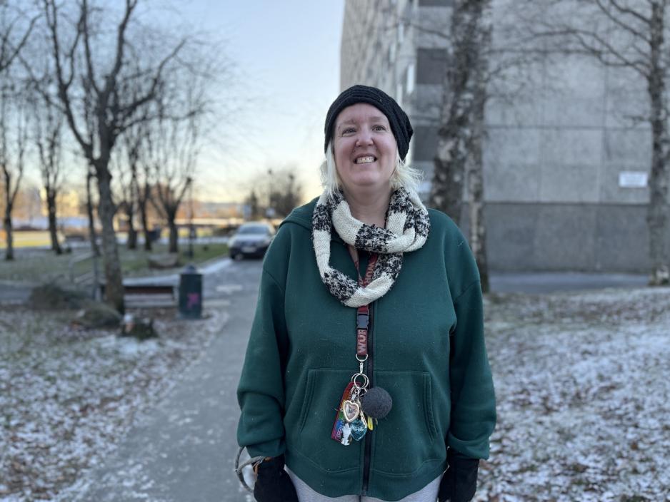 Dame som smiler utenfor boligblokk