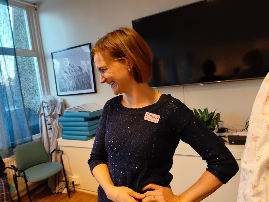 Korleder ser ned og smiler mens hun holder seg i siden