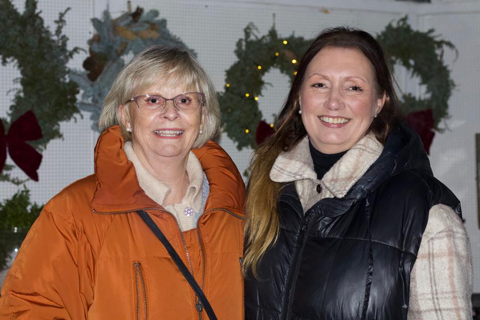 Therese Lunde og Ruth Moe står foran julemarkedet.